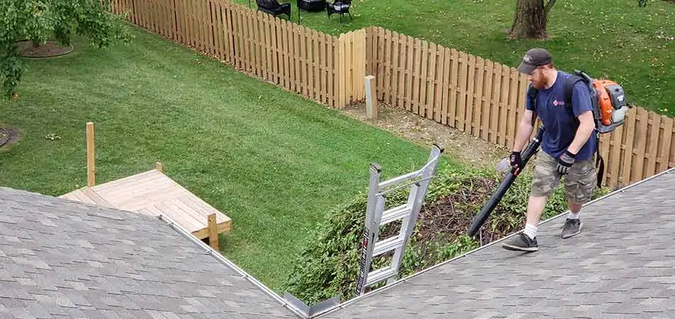 A Tri-City Property Maintenance team member blowing out the gutters of a Midland homeowner.