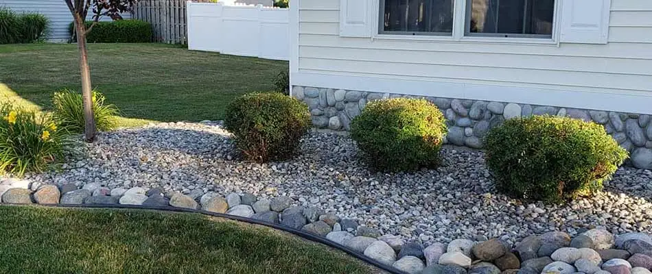 Home with rock landscape bed and trimmed plants in Midland, MI.